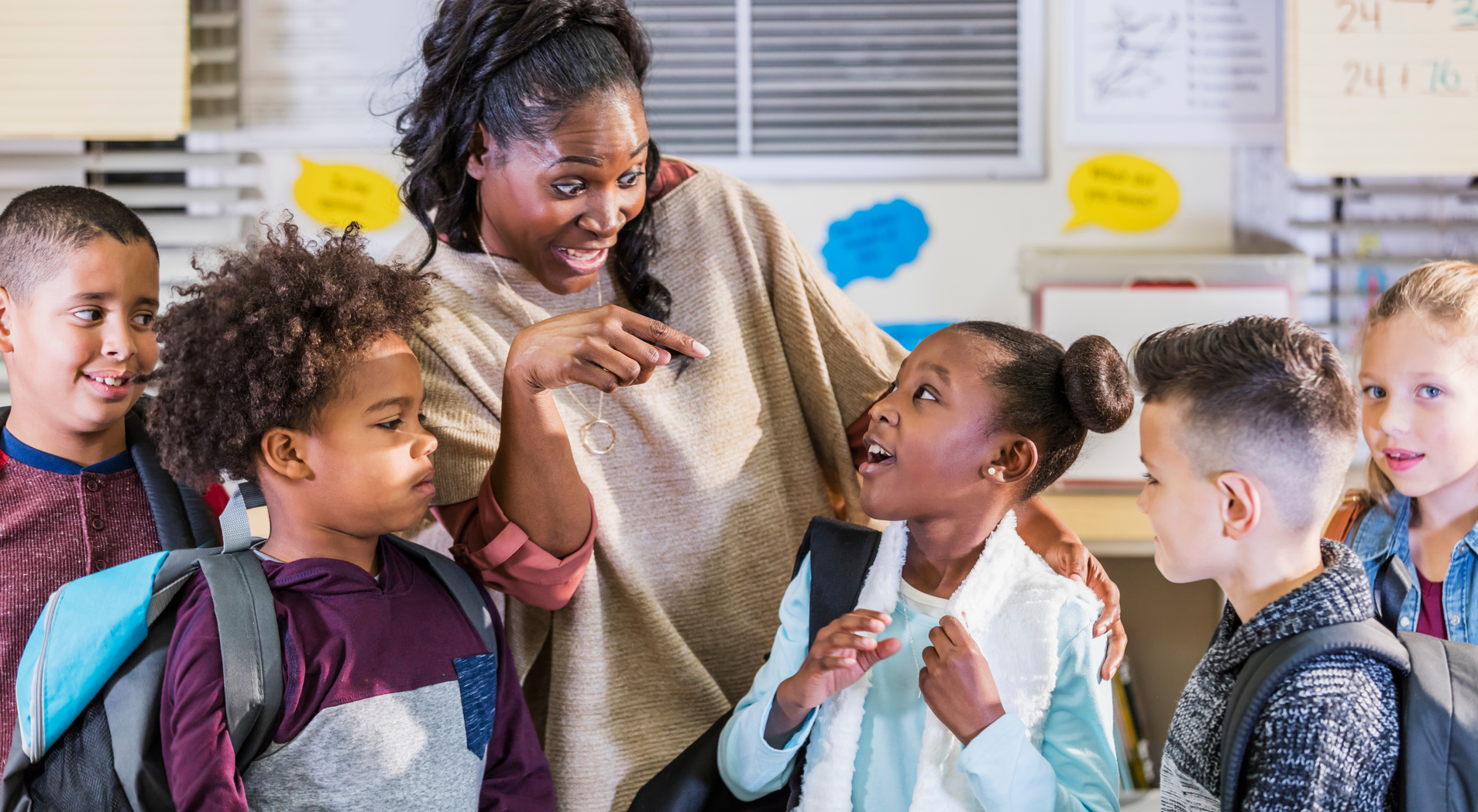 Multi-ethnic elementary students, teacher in classroom