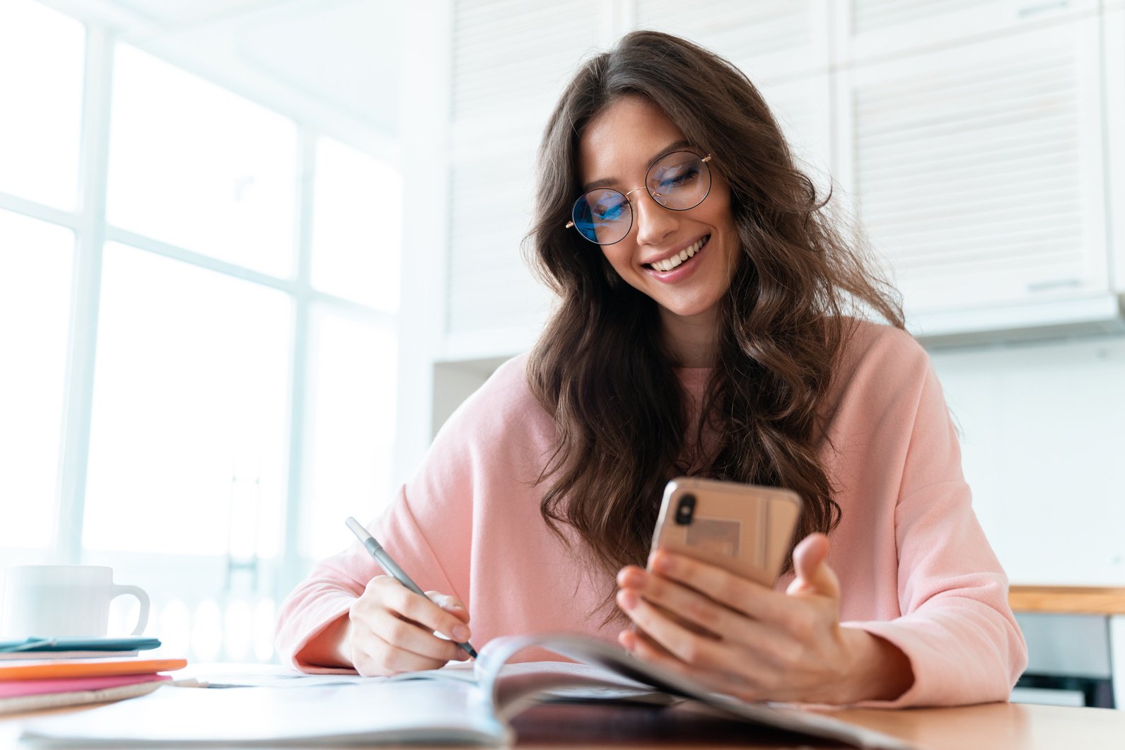 Woman with Phone Writes Notes